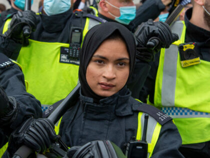 LONDON, UNITED KINGDOM - 2020/09/26: Woman Police officer without a face mask, holding a b