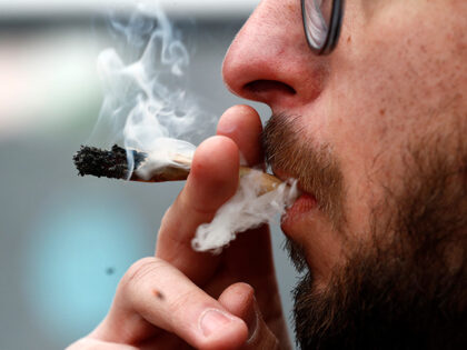 A demonstrator smokes marijuana during the "Cultivate Your Rights" march demanding its leg