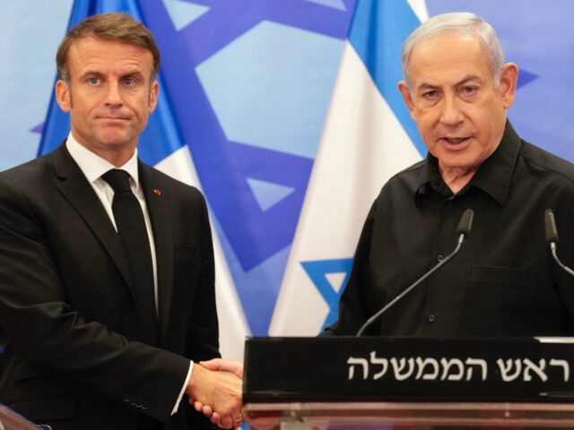 TOPSHOT - Israeli Prime Minister Benjamin Netanyahu (R) shakes hands with French President