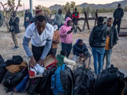 An immigrant from Mauritania repacks a new pair of Pumas after crossing the U.S.-Mexico bo