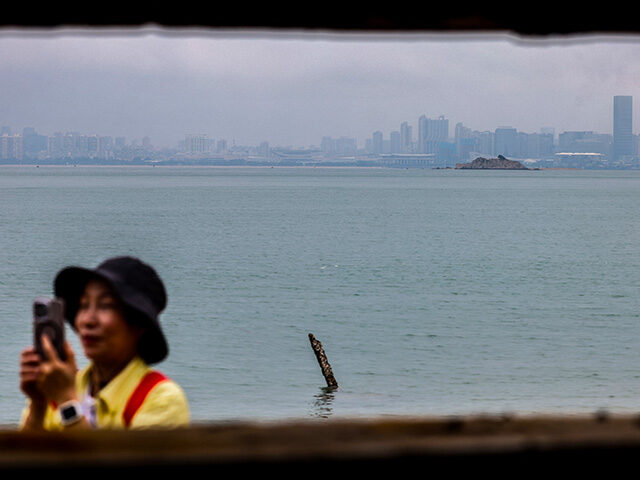 A tourist uses her mobile phone to take pictures at Shuang Kou Coastal Park in Kinmen, bef