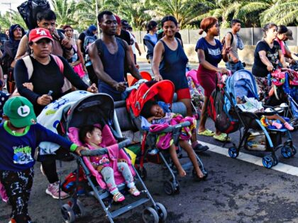 Migrants, mostly from Central America and Venezuela, walk towards the United States on the