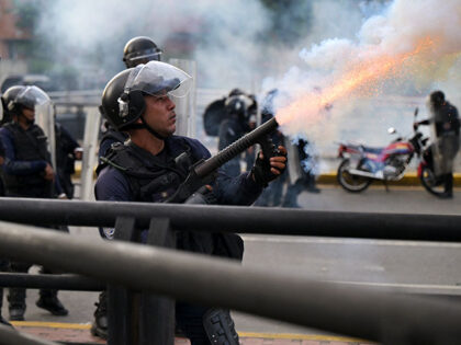 A police officer fires tear gas during a protest against President Nicolas Maduro's govern