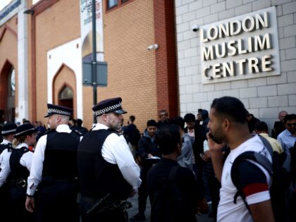 Police officers stand guard outside the East London Mosque after Friday prayers in Tower H