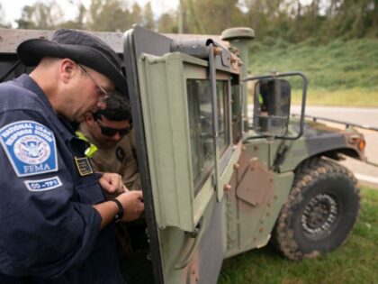 A FEMA response team member works with a guard member at Crooked Creek Fire Department nea