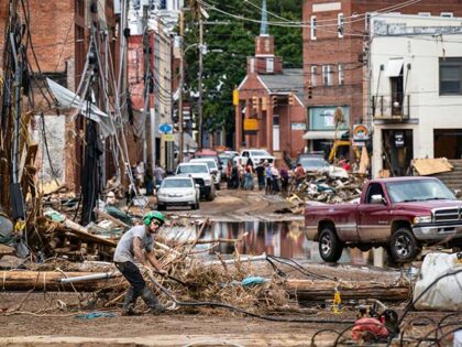 Workers, community members, and business owners clean up debris in the aftermath of Hurric