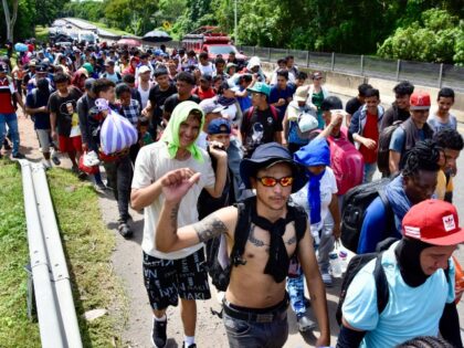 Migrants of different nationalities walk towards the United States on a highway in Tapachu