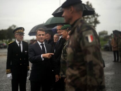 France's President Emmanuel Macron (C), flanked by Marne's prefect Henri Prevost (L) revie