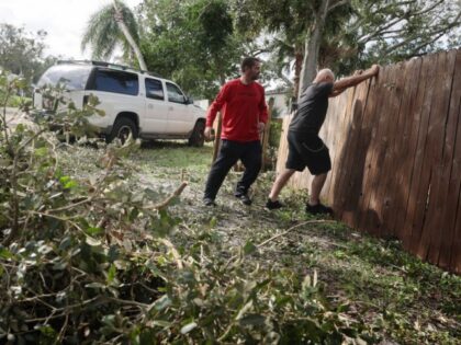 Men work on cleaning-up after the arrival of Hurricane Milton on October 10, 2024 in Gulfp