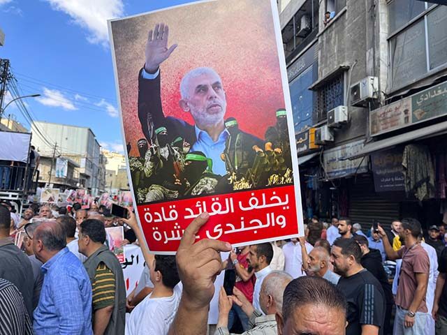 People, holding banners and Palestinian flags, gather to protest against Israeli attacks o