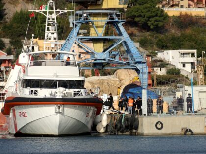 A group of migrants embark on an Italian coast guard ship at Shengjin port in Albania on O