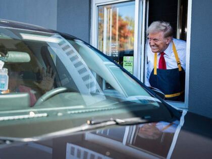 Republican presidential nominee former President Donald Trump hands out food while standin