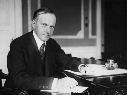 Calvin Coolidge (1872-1933), 30th President, sitting at his desk.