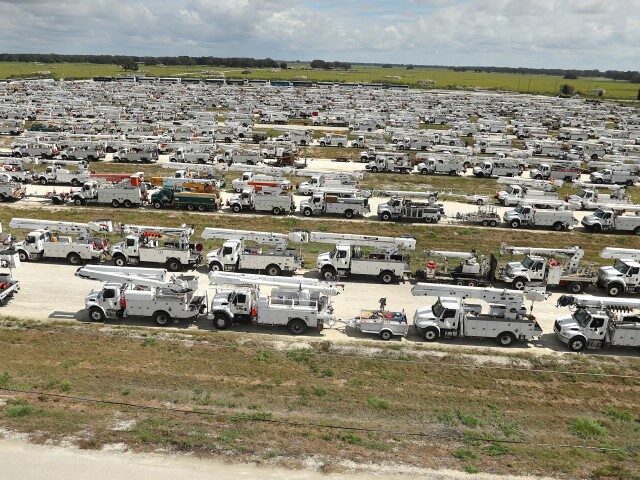 Linemen gather in front of hundreds of utility trucks staged at The Villages, Florida, on