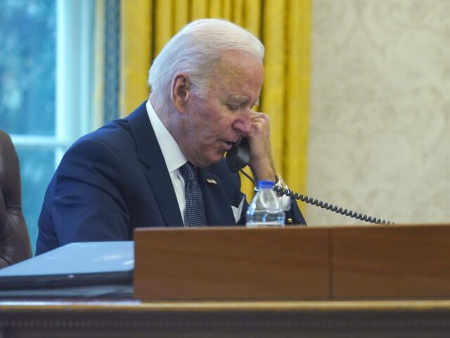 In this image made through a window, President Joe Biden talks on the phone with Ukrainian