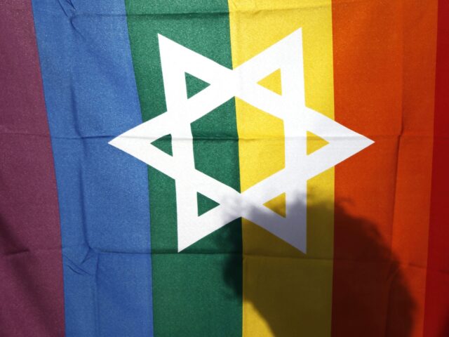 FILE - In this file photo taken on June 25, 2009, an Israeli man walks behind a pride flag