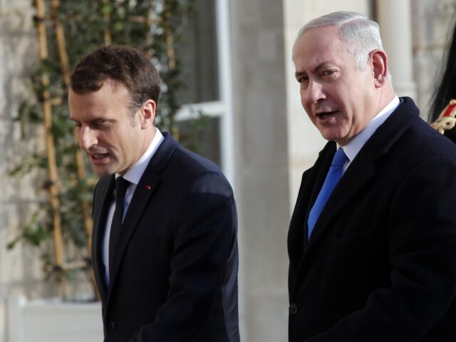 French President Emmanuel Macron, left, greets Israeli Prime Minister Benjamin Netanyahu b