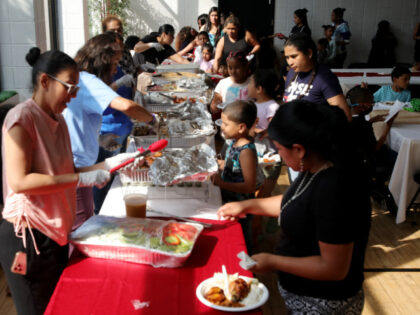 People attend a dinner for asylum seeker families at Romemu Center in New York City on Jun