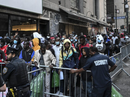 Police officers take security measures during migrants line up outside Roosevelt Hotel whi