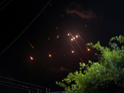 Missiles launched from Iran towards Israel streak across the night sky as seen from Deir a