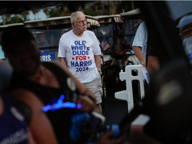 A man wears a tee-shirt reading "Old White Dudes for Harris" as he waits for second gentle