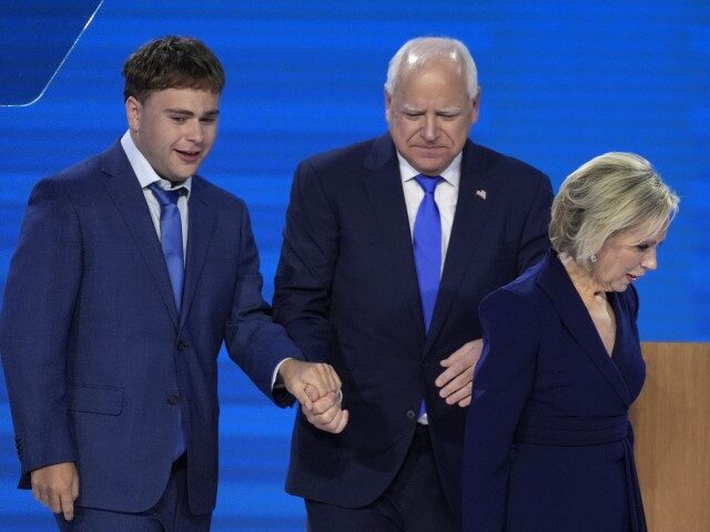 Democratic vice presidential nominee Minnesota Gov. Tim Walz, center, walks off stage with