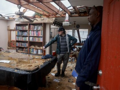 Connor Ferran (L) and his neighbor Leroy Roker survey what is left after what appeared to