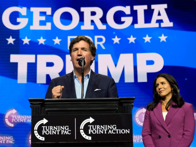 Tucker Carlson speaks as former Democratic Rep. Tulsi Gabbard listens during a campaign ra