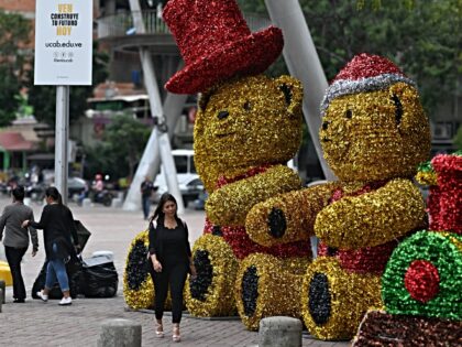 A woman walks past giant Christmas decorations in Caracas on October 1, 2024. Venezuelan P