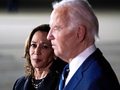 US Vice President Kamala Harris, left, watches as President Joe Biden speaks to members of