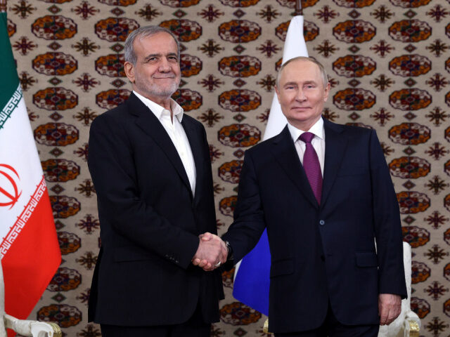 Russian President Vladimir Putin, right, and Iranian President Masoud Pezeshkian shake han