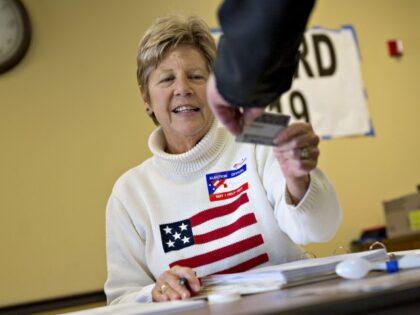 A poll worker checks the identification of a resident at polling location during the presi