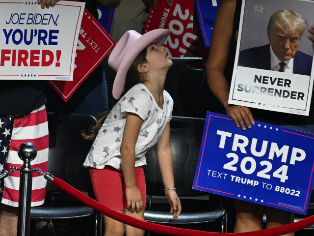 A young girl looks on as former US President and 2024 Republican presidential candidate Do