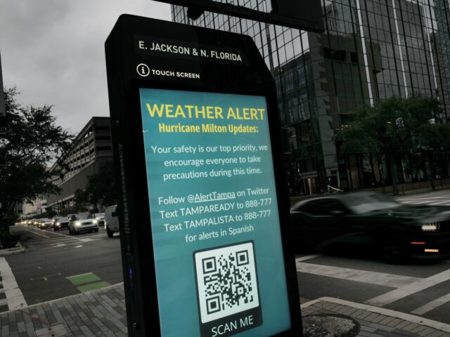 TAMPA, FLORIDA - OCTOBER 07: A weather alert is displayed along a sidewalk as Hurricane Mi