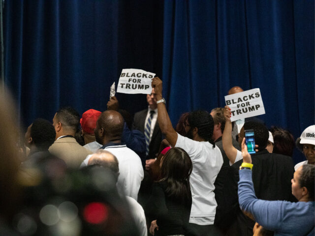 Attendees hold signs that read 