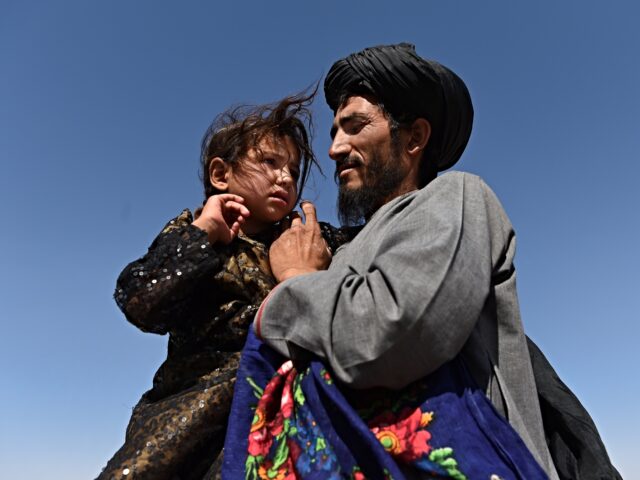 Abdul Haq (right) holds his 4 year old daughter Khadija (left) in Regreshan camp for the i