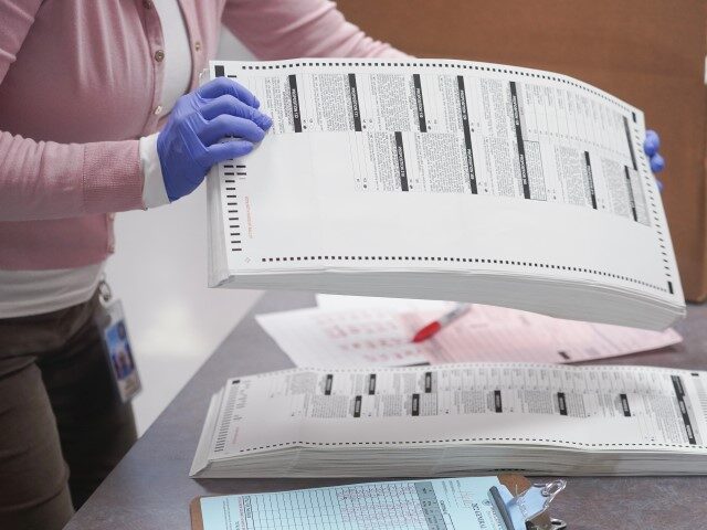 FILE - An election worker gathers tabulated ballots to be boxed inside the Maricopa County