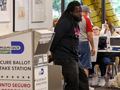 Poll workers assist voters as they arrived at the Coral Gables Library to cast their vote