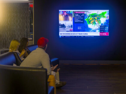 ORLANDO, FLORIDA - OCTOBER 9: People watch the weather report at a restaurant as the commu