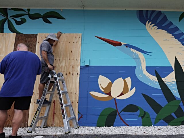 ST. PETERSBURG, FLORIDA - OCTOBER 07: Boards are placed over the windows of a bar as the s