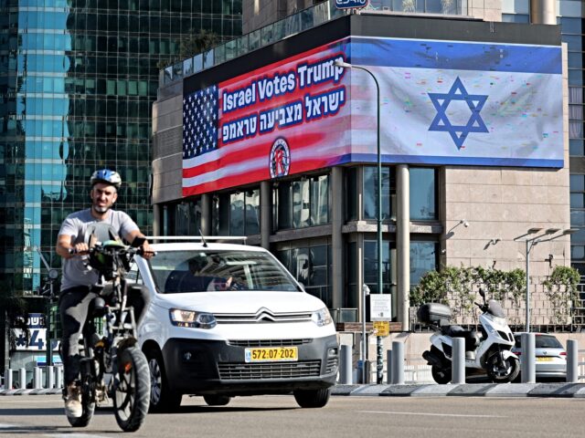 Israel Votes Trump Commuters drive along a road in front of a a billboard bearing the flag