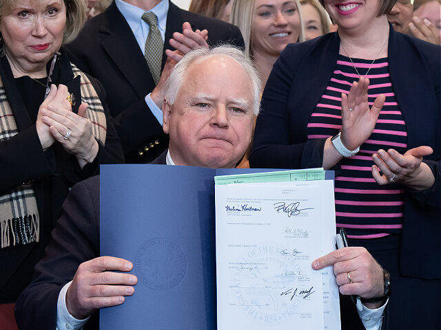 ST. PAUL, MN. - JANUARY 2023: Surrounded by DFL legislators, Gov. Tim Walz signs a bill to