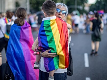 MADRID, SPAIN - 2023/07/01: A woman carries her son who wrapped with an LGTBI+ flag during