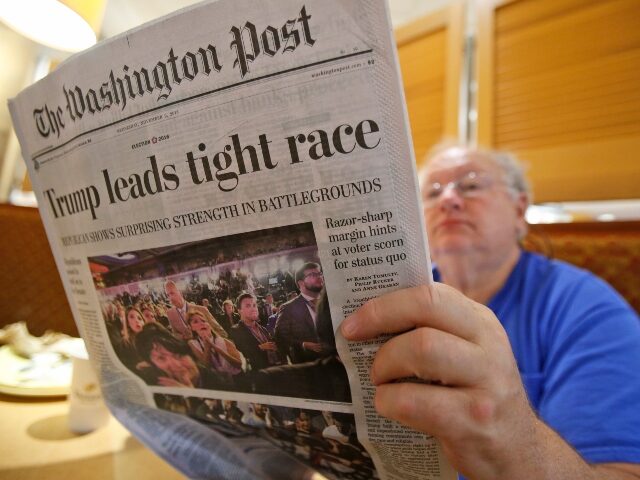 Joseph Van Meter,of Falls Church Va., reads a morning paper at a coffee shop in Falls Chur