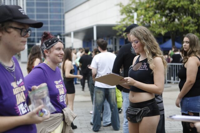 Amelia Zehnder (C), a "Yes On 4!" volunteer, talks with concert-goer Gigi Forbriger on end