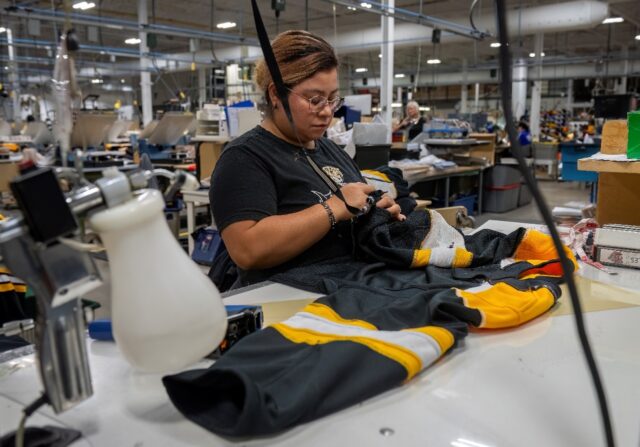 An employee works on a jersey at SP Apparel in Saint-Hyacinthe, Quebec; the Canadian firm