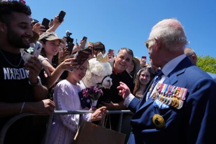 Britain's King Charles III chats with the owner of an alpaca named Hephner before leaving