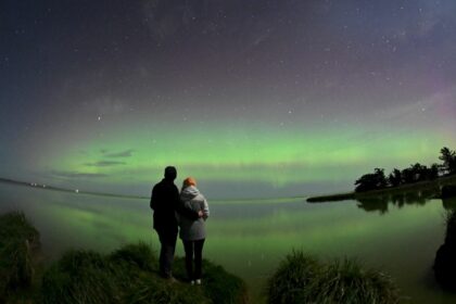 A couple looks out at the southern lights on the outskirts of Christchurch in New Zealand