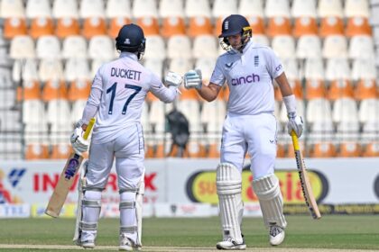 England's Joe Root (right) is congratulated by Ben Duckett after breaking Alastair Cook's