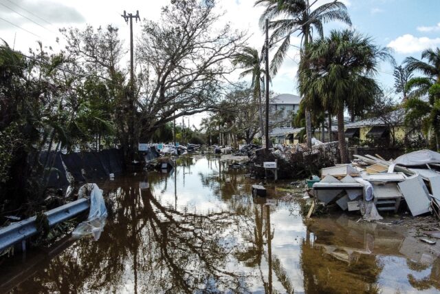 A flooded street with debris in the aftermath of Hurricane Milton in Siesta Key, Florida,